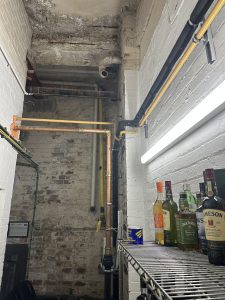 wide shot of a 54mm copper pipe coming from a commercial waste sump pump.