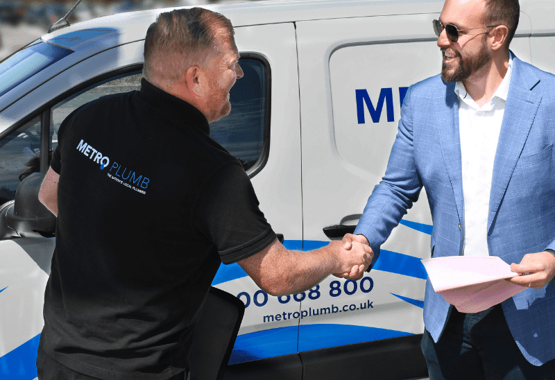 A plumber shaking hands with a businessman