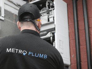 A picture of our Metro Plumb plumber working on a boiler