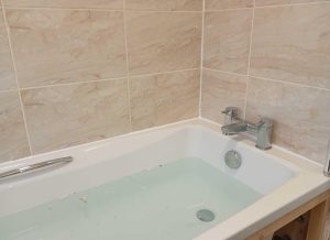 Bath resealed and repaired with new silicone sealant.